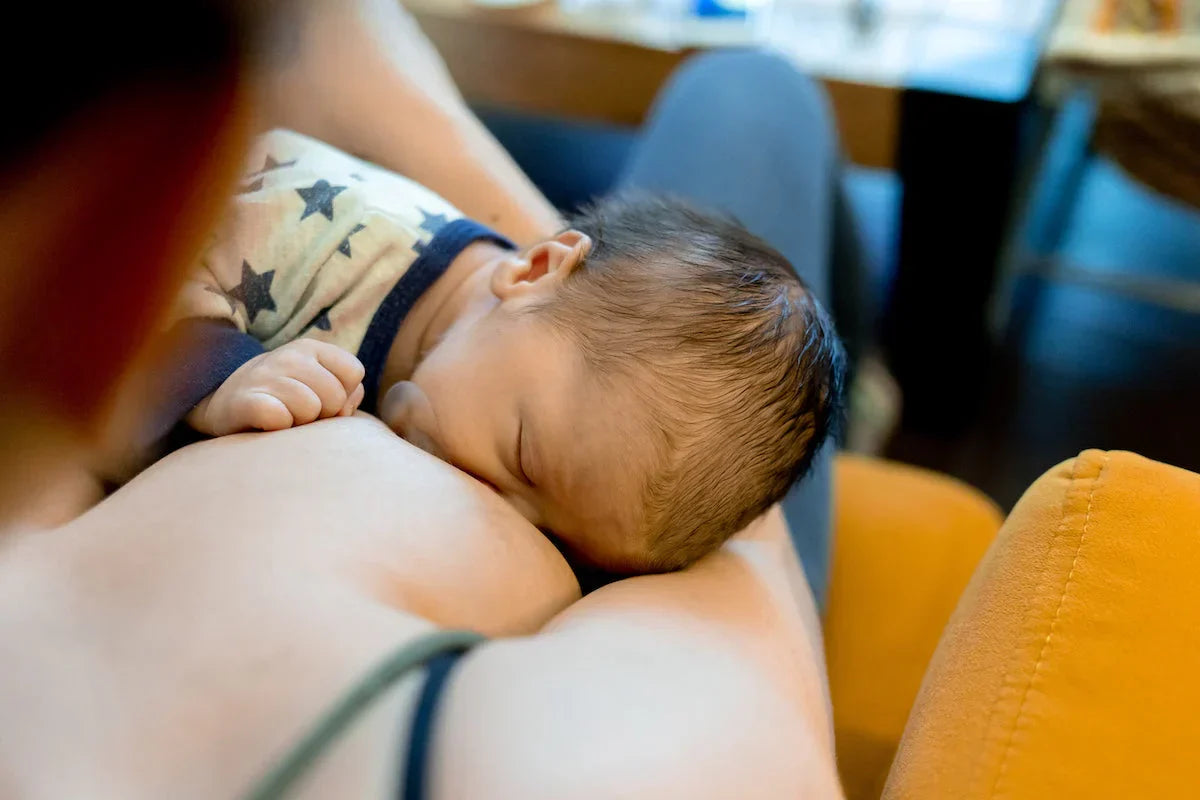 Newborn baby being breastfed by a woman in a casual setting