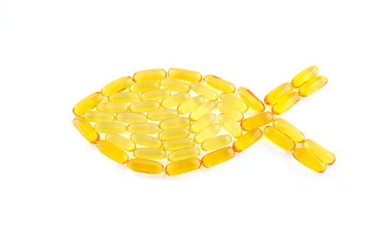 Fish shape creatively formed using golden omega-3 fish oil capsules on a white background, symbolizing the source and benefits of fish-derived supplements.