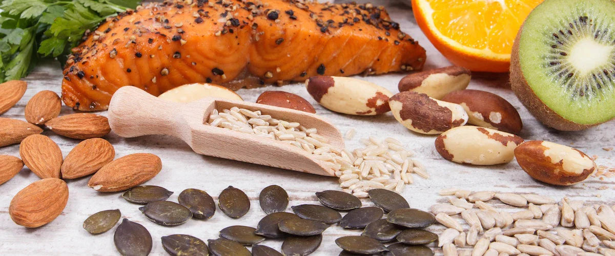 Salmon, Kiwi, Orange, Almond and seeds on a wooden ground