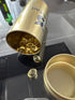 Gold container with a lid on a reflective surface