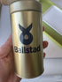 Gold container with 'Ballstad' logo held by a hand against a blurred background